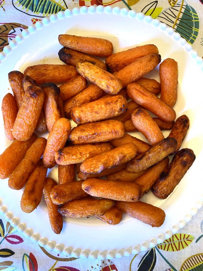 serving air fried carrots with honey and cinnamon on a white plate