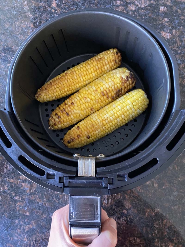 cooked corn on the cob in an air fryer basket 