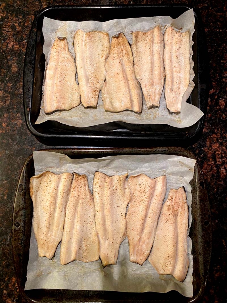 two baking sheets full of oven-baked rainbow trout 