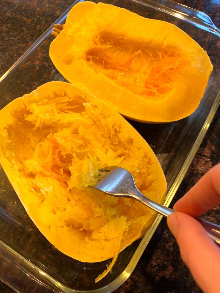microwaved spaghetti squash separated into strands with a fork