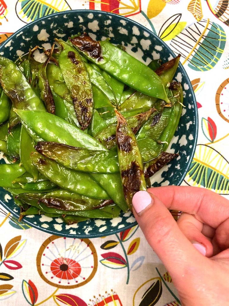 eating snow peas in a blue bowl 