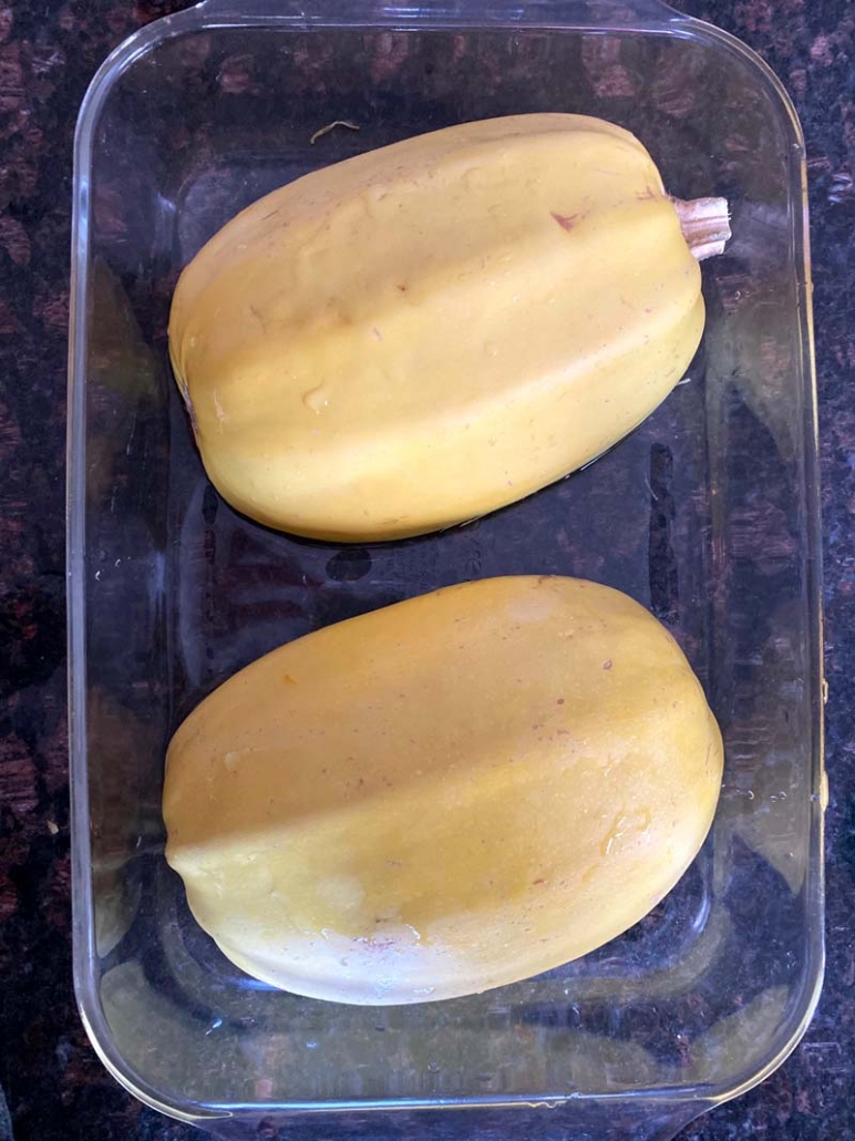 spaghetti squash halves in a microwave-safe dish