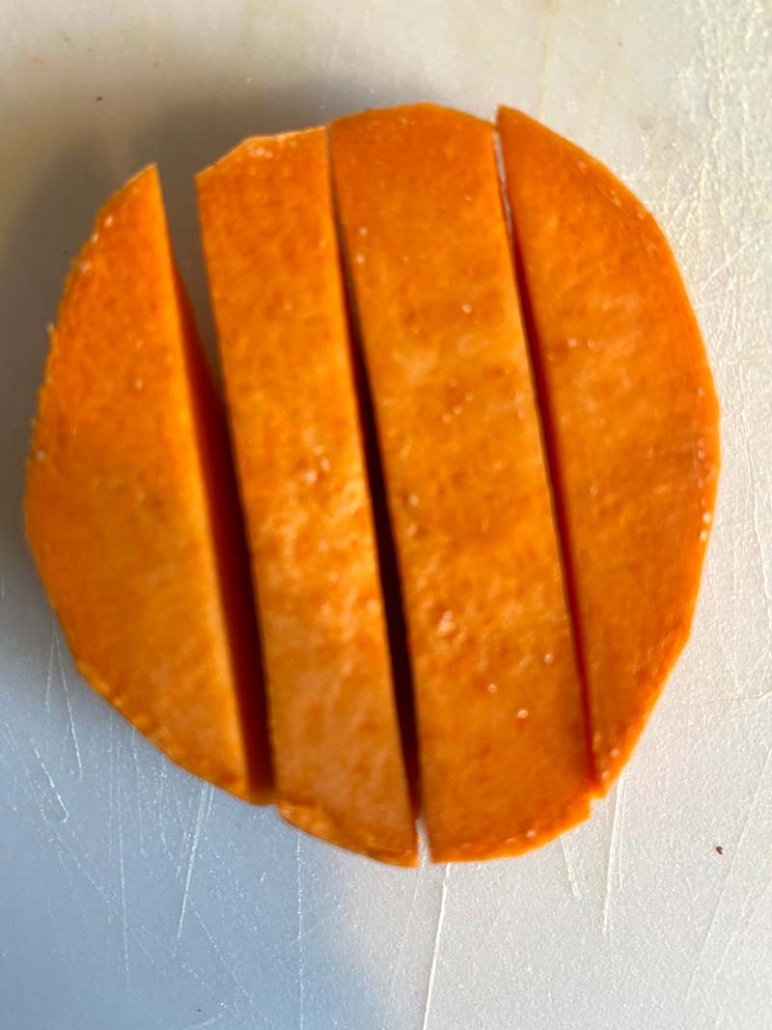 cutting a sweet potato into strips for french fries 