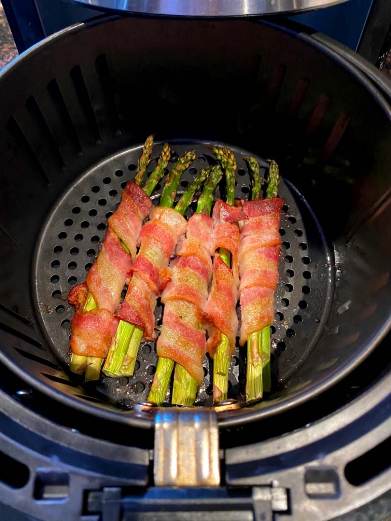 asparagus wrapped in bacon cooking in the air fryer