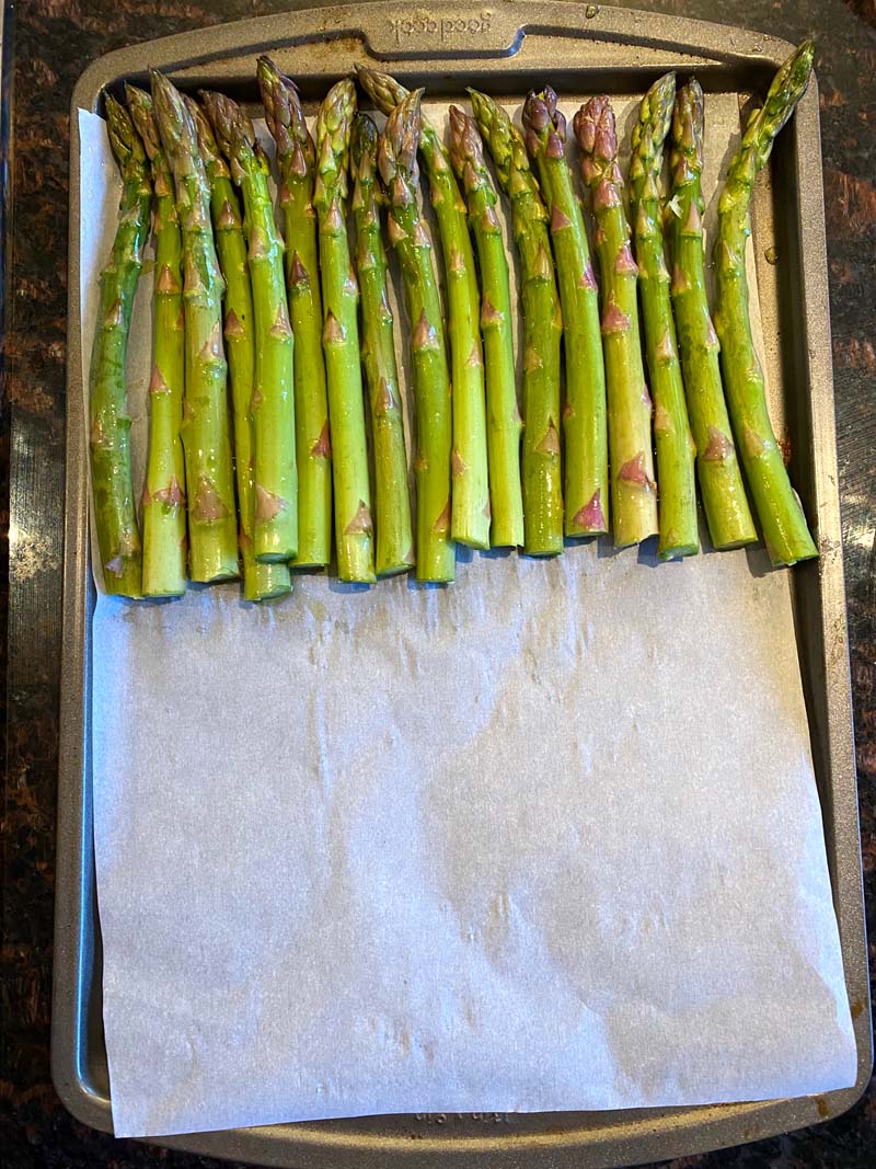 Asparagus lined up on a baking sheet