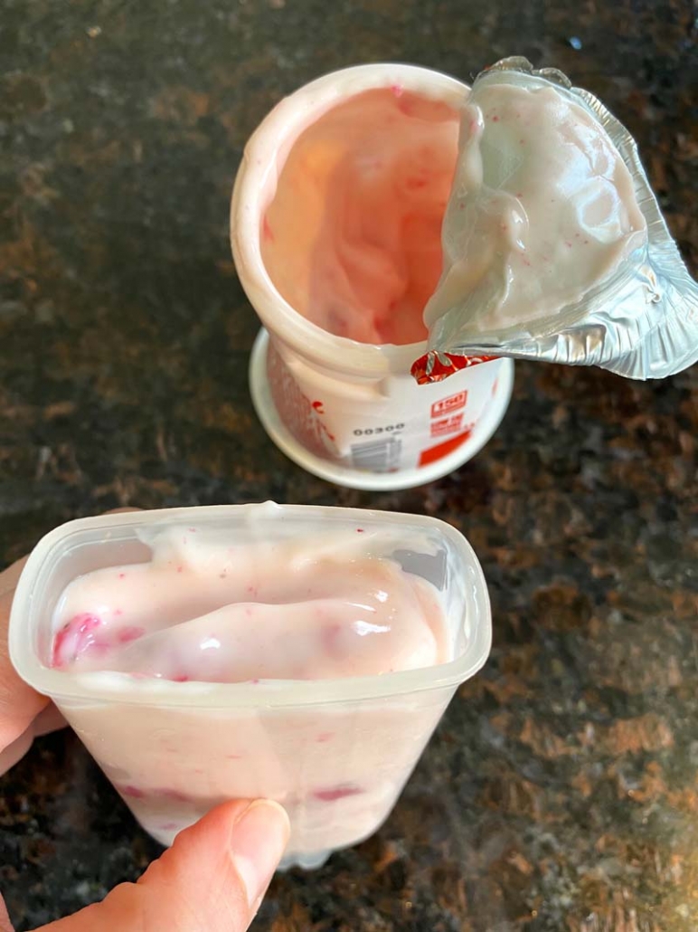 filling a popsicle mold with strawberry yogurt