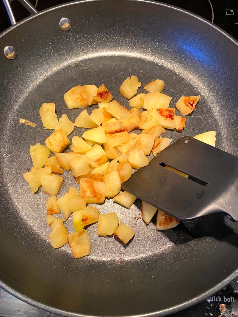 Moving the apples n a skillet with a spatula
