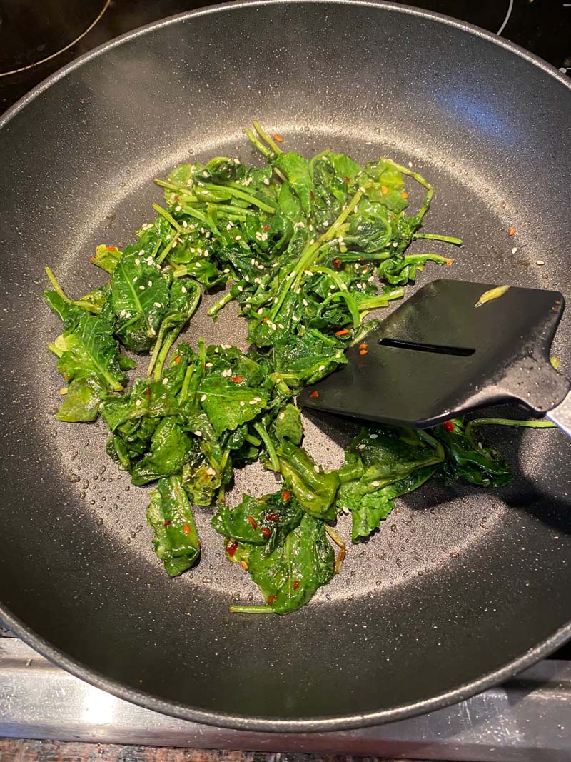 Sautéing the kale in a skillet with a spatula