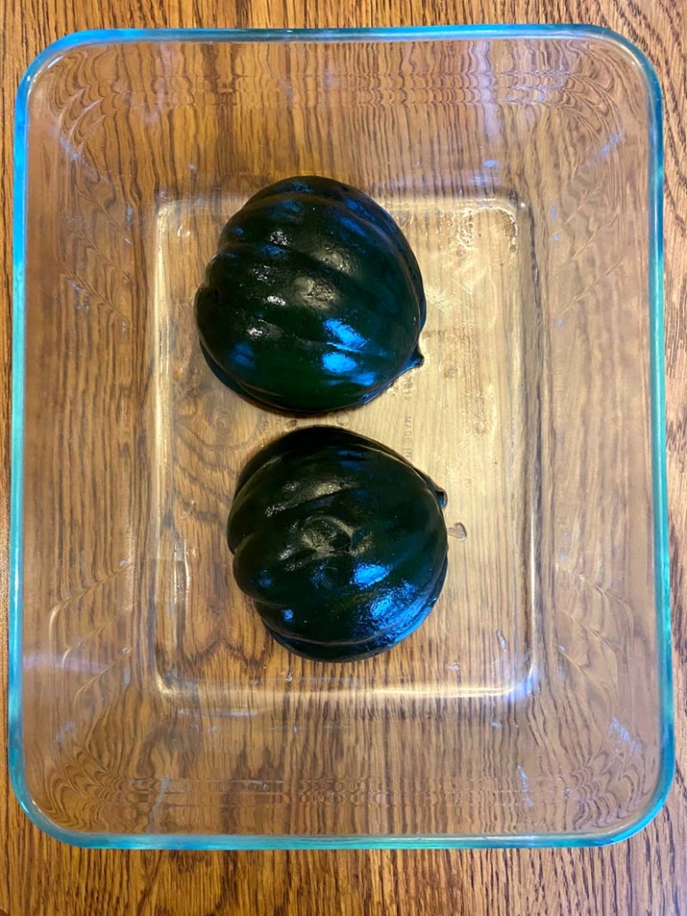 halved acorn squash in a glass container