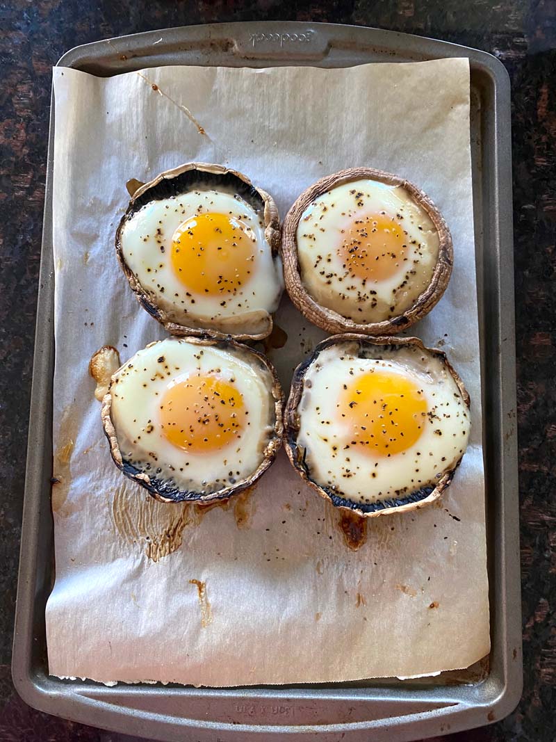 Four baked eggs in mushroom caps