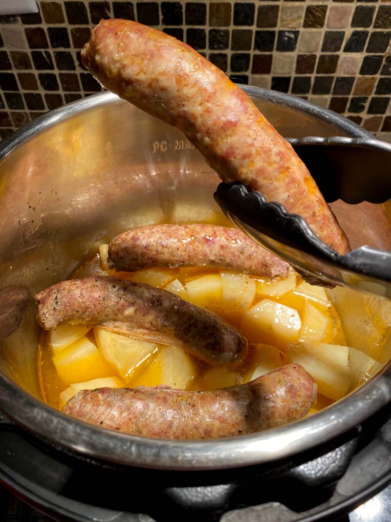 Lifting a sausage out of the instant pot with some tongs