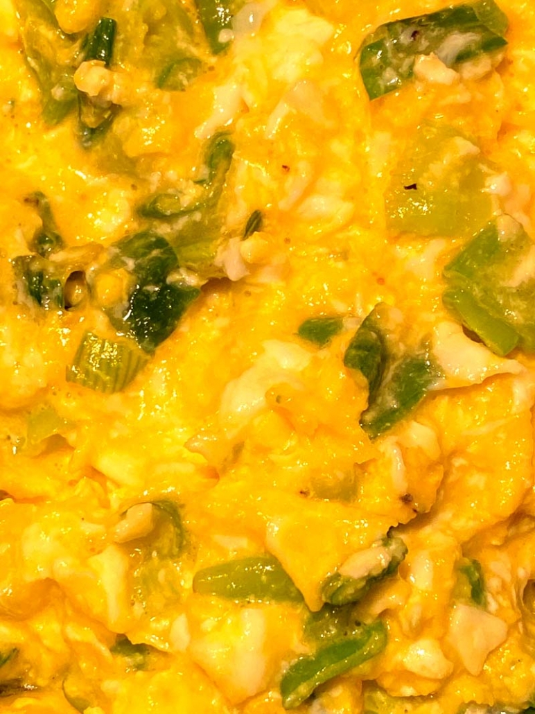 scrambled eggs with chopped green onions and shredded cheese