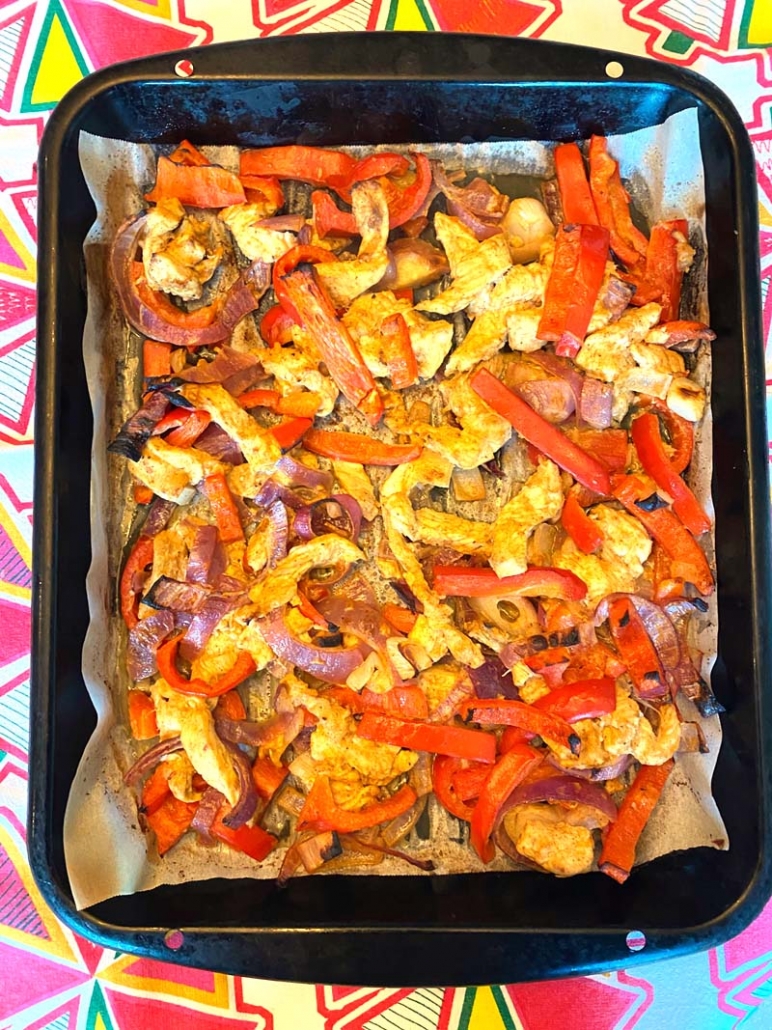 chicken, peppers and onions cooked on a sheet pan 