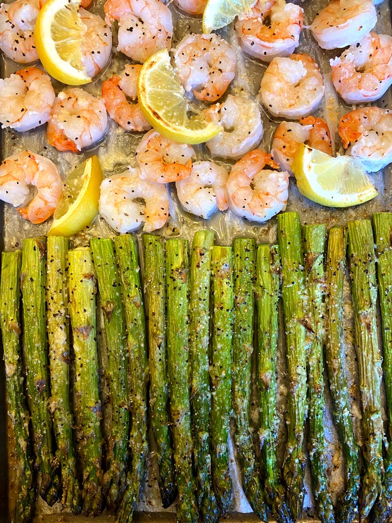 close up of asparagus and shrimp on a baking sheet