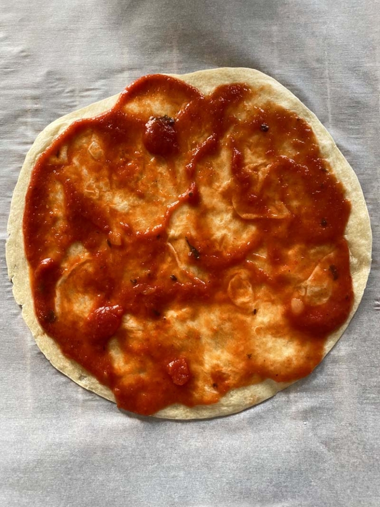 Tomato sauce spread on a tortilla