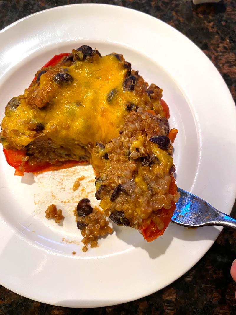 A stuffed pepper on a white plate with a fork