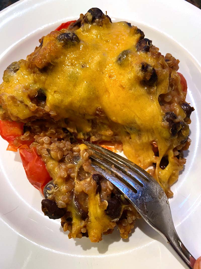Clos eup of a fork cutting into a baked vegetarian stuffed pepper