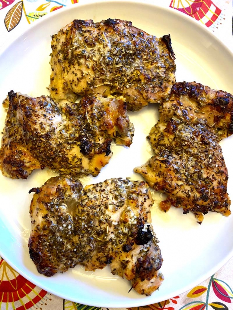 baked greek lemon chicken thighs on a white plate 