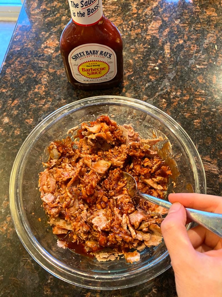 adding sweet baby ray's bbq sauce to shredded beef 