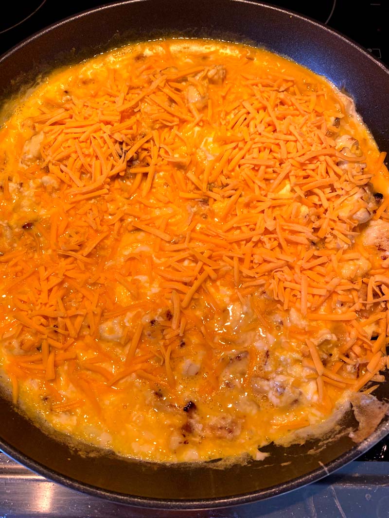 eggs and shredded cheese added to the skillet