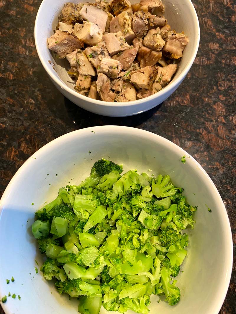 bowl of chicken next to a bowl of broccoli