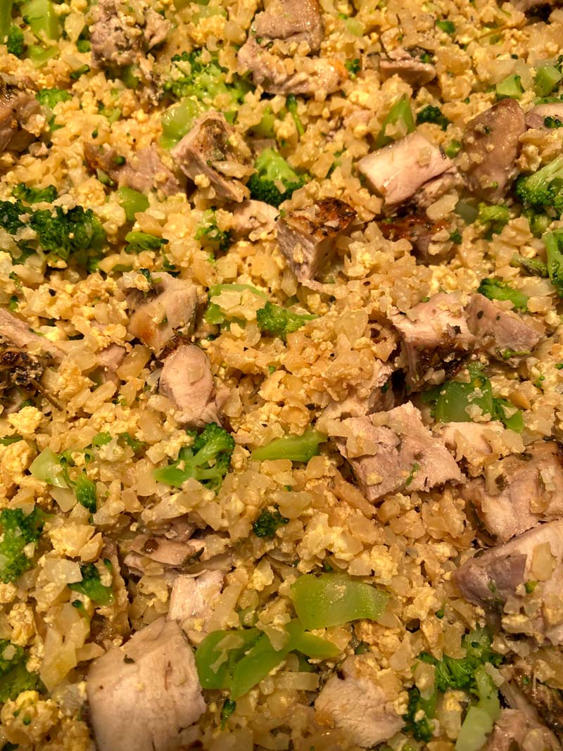 Close up of cauliflower fried rice with chicken and broccoli