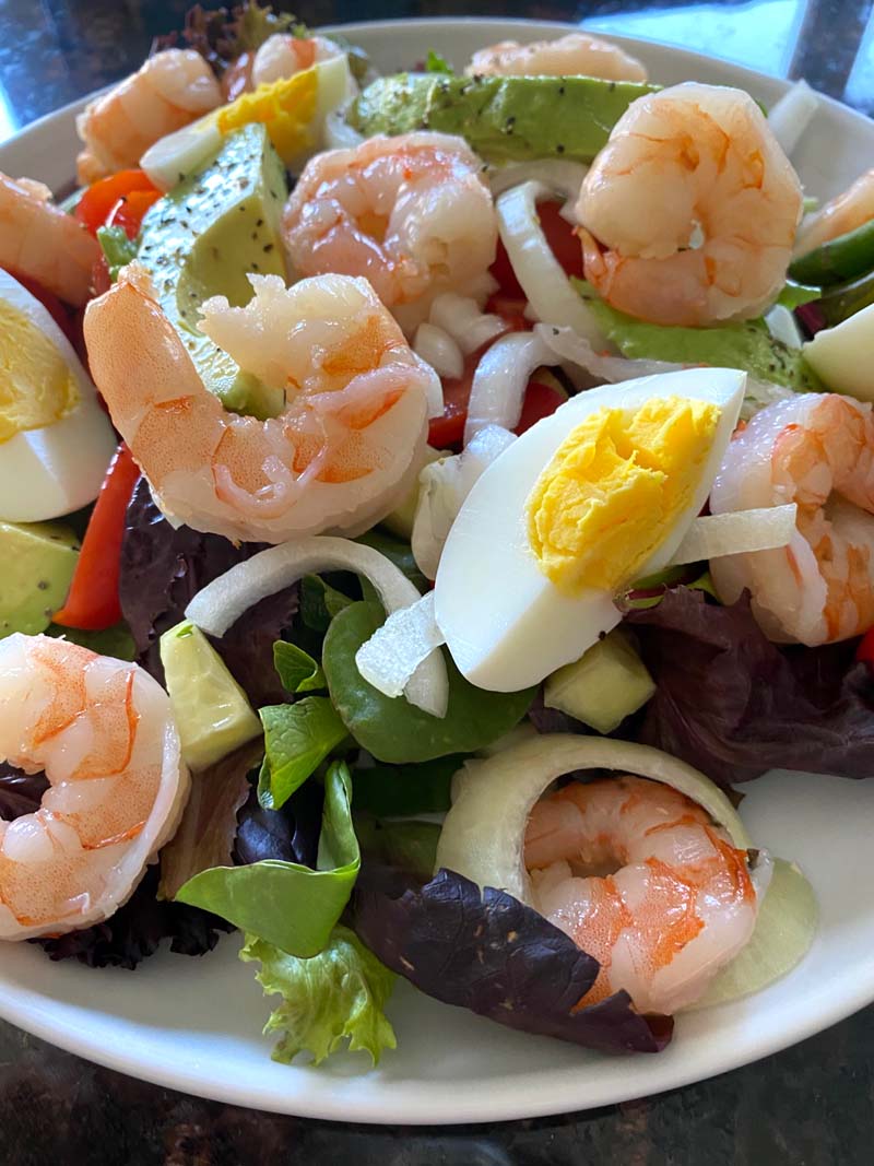 A bowl of shrimp egg avocado salad 