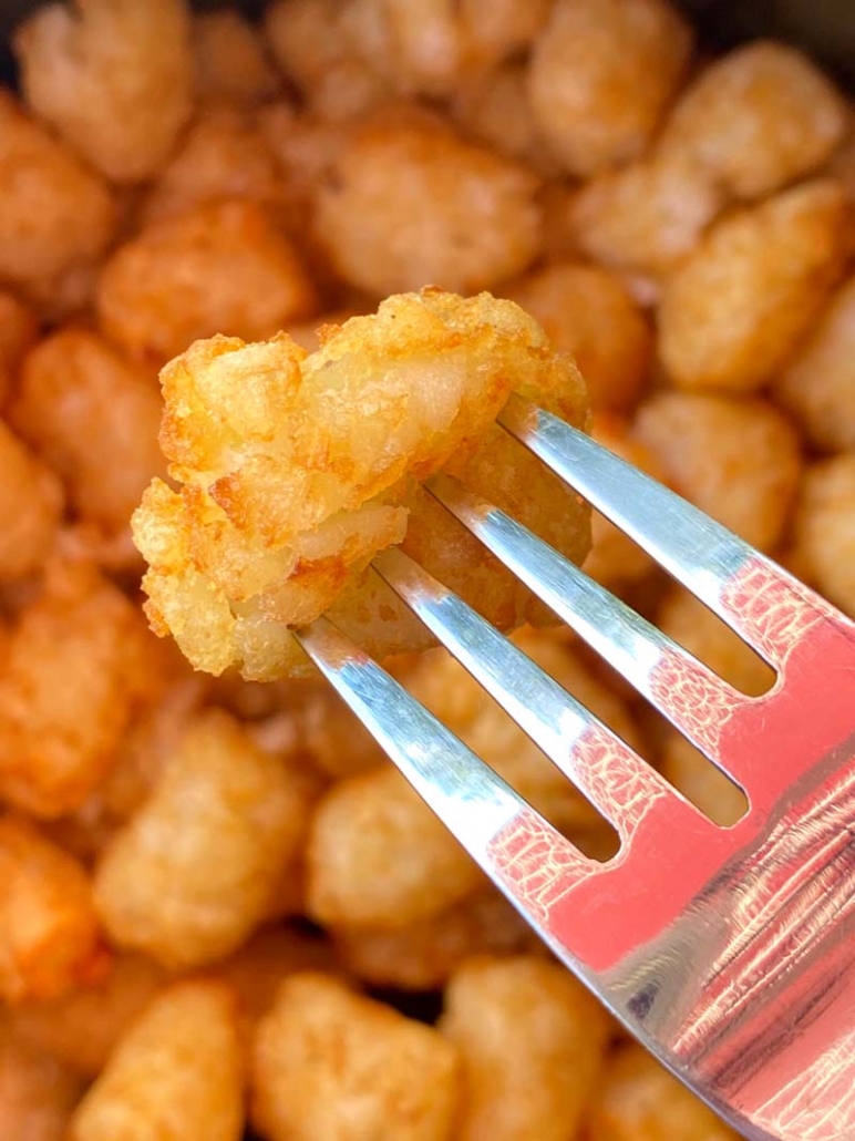 eating tater tots with a fork