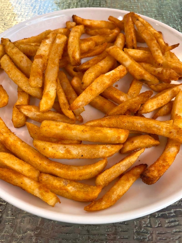 cooked french fries on a white plate