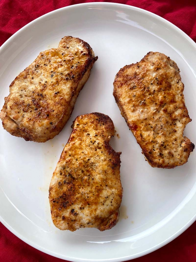 3 cooked pork chops on a plate 