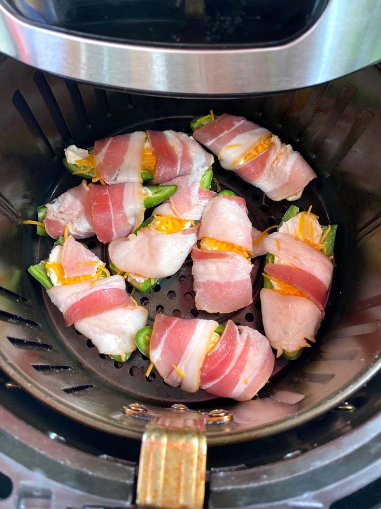 Bacon-Wrapped Jalapeno Poppers in an air fryer before they are baked 