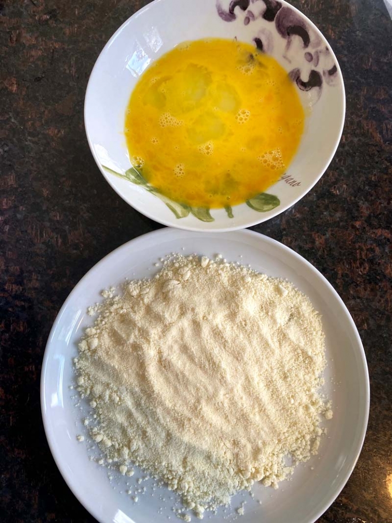 Almond flour in a bowl next to egg in another bowl