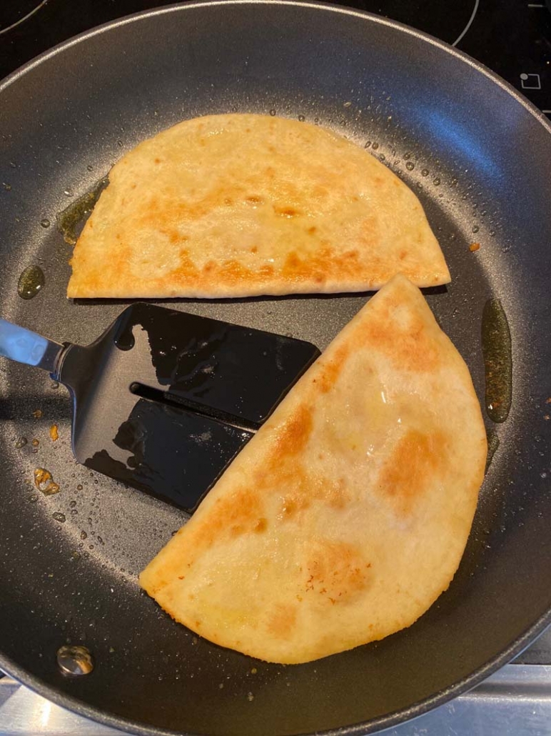 Using a spatula to flip the hummus quesadilla