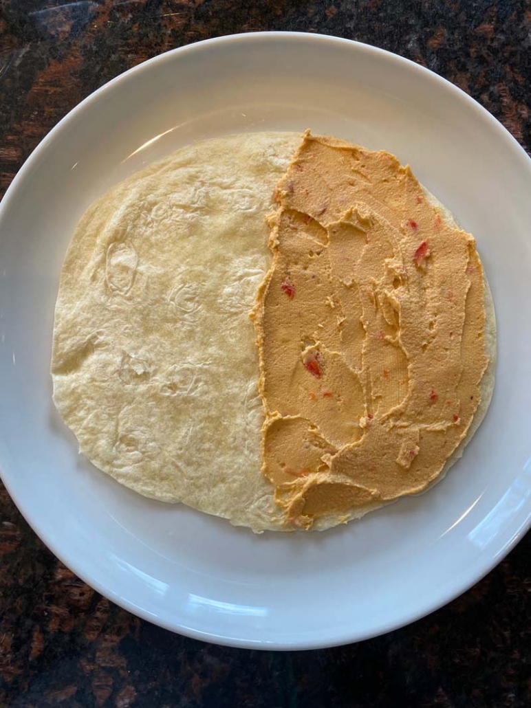 Hummus on one side of a flour tortilla