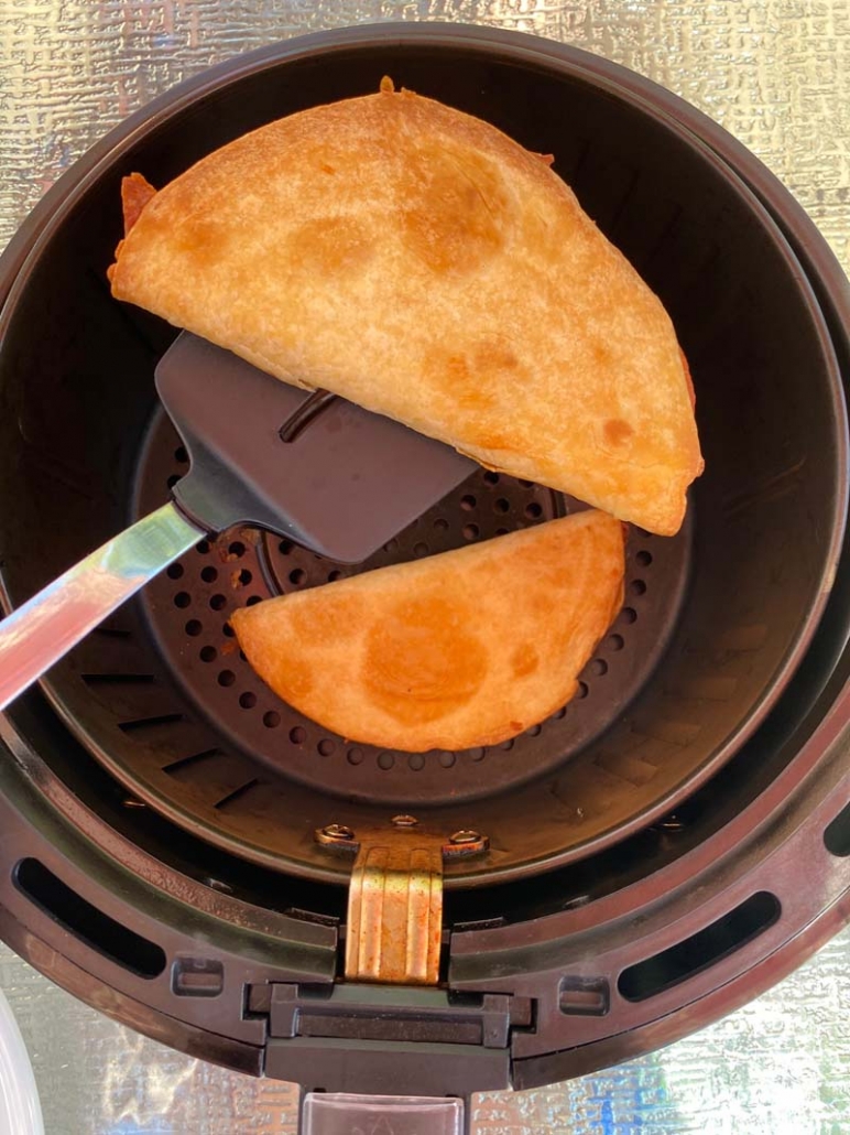 using a spatula to take out quesadilla from air fryer basket