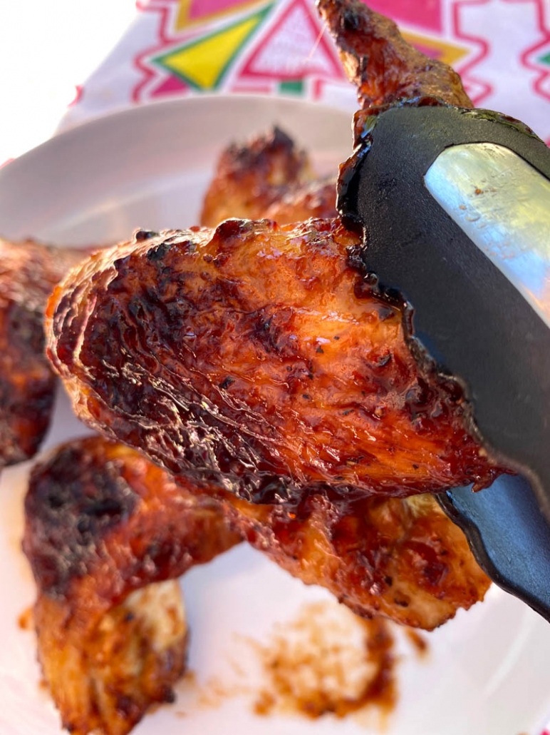 serving bbq chicken wings with tongs