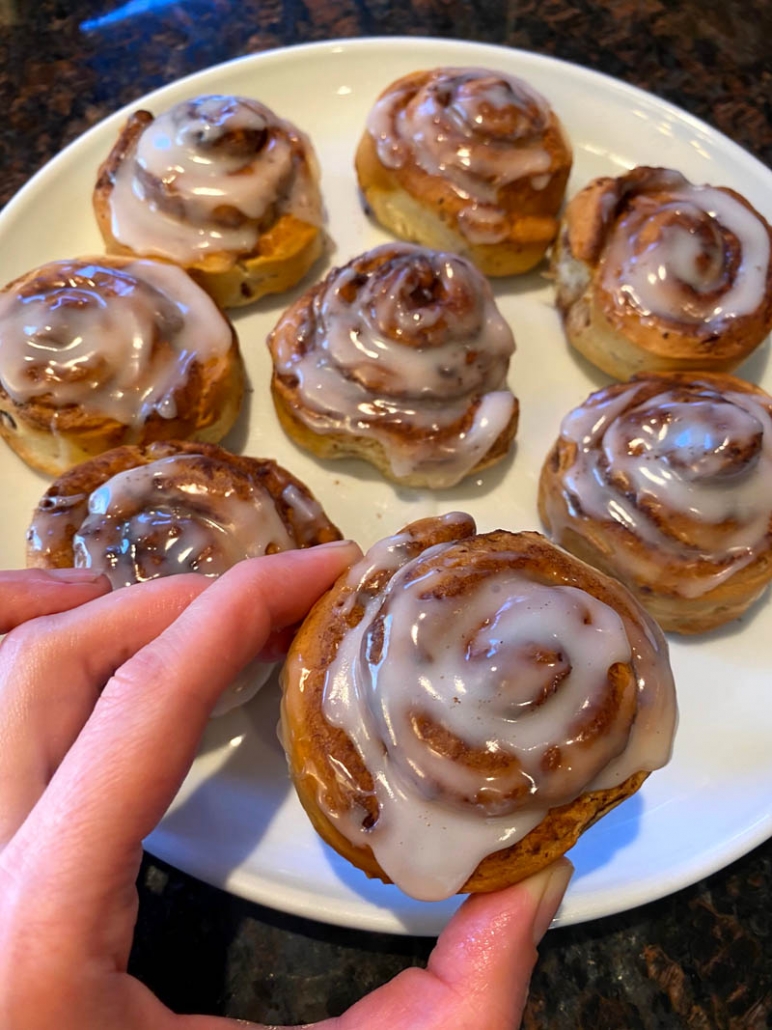 glazed cinnamon rolls on a white plate 