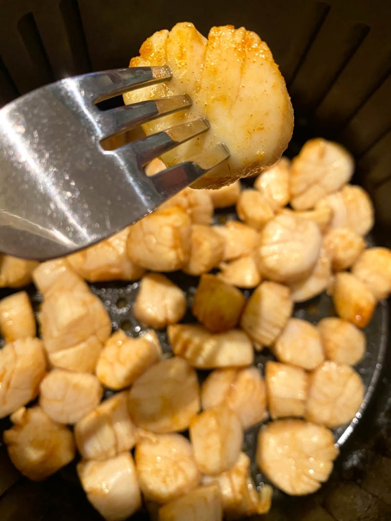 eating air fried scallops with a fork 