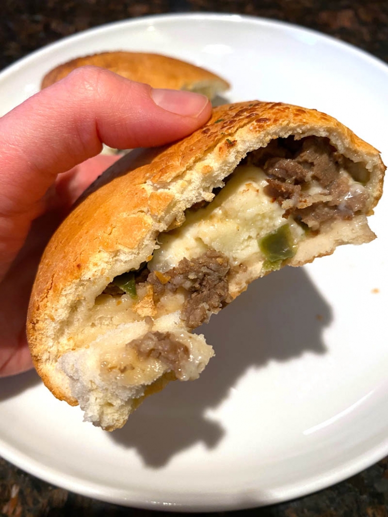 philly cheese steak calzone on a white plate 