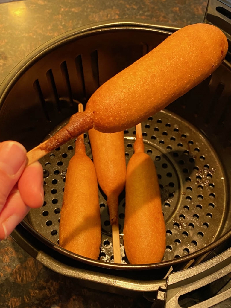 serving corn dogs from the air fryer basket 