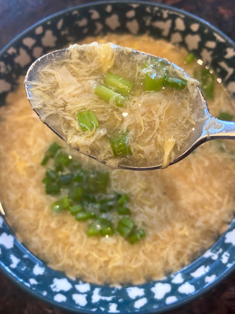 eating homemade egg drop soup with green onions