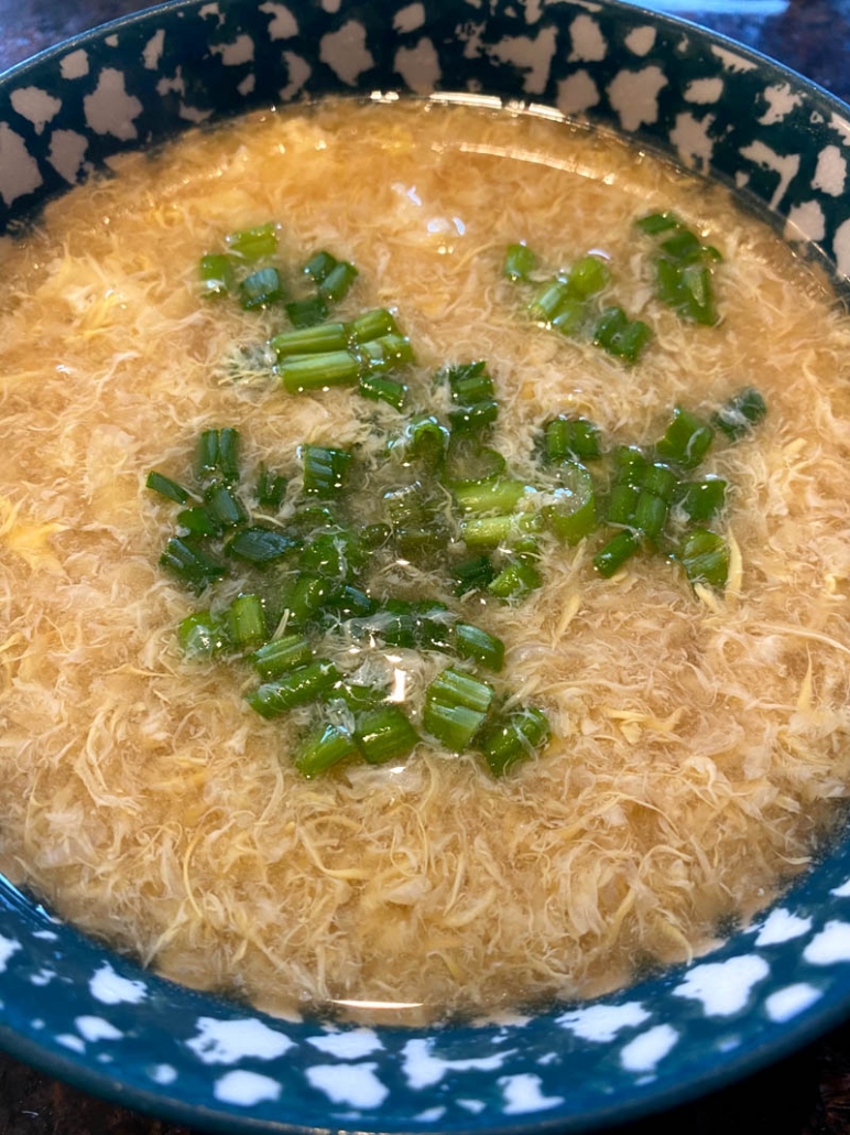 homemade egg drop soup in a bowl with chopped green onions