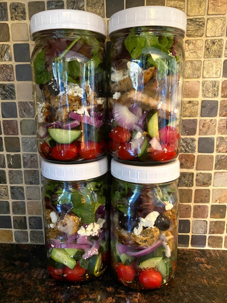 4 mason jars meal prepped with greek chicken salad 