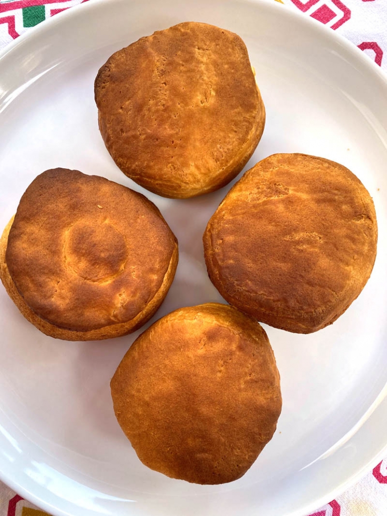 4 baked butter biscuits on a white plate 