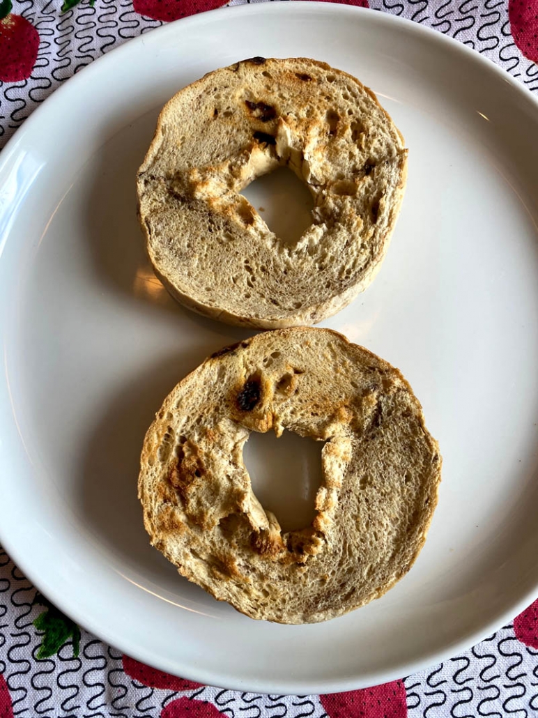 toasted bagels halves on a white plate 