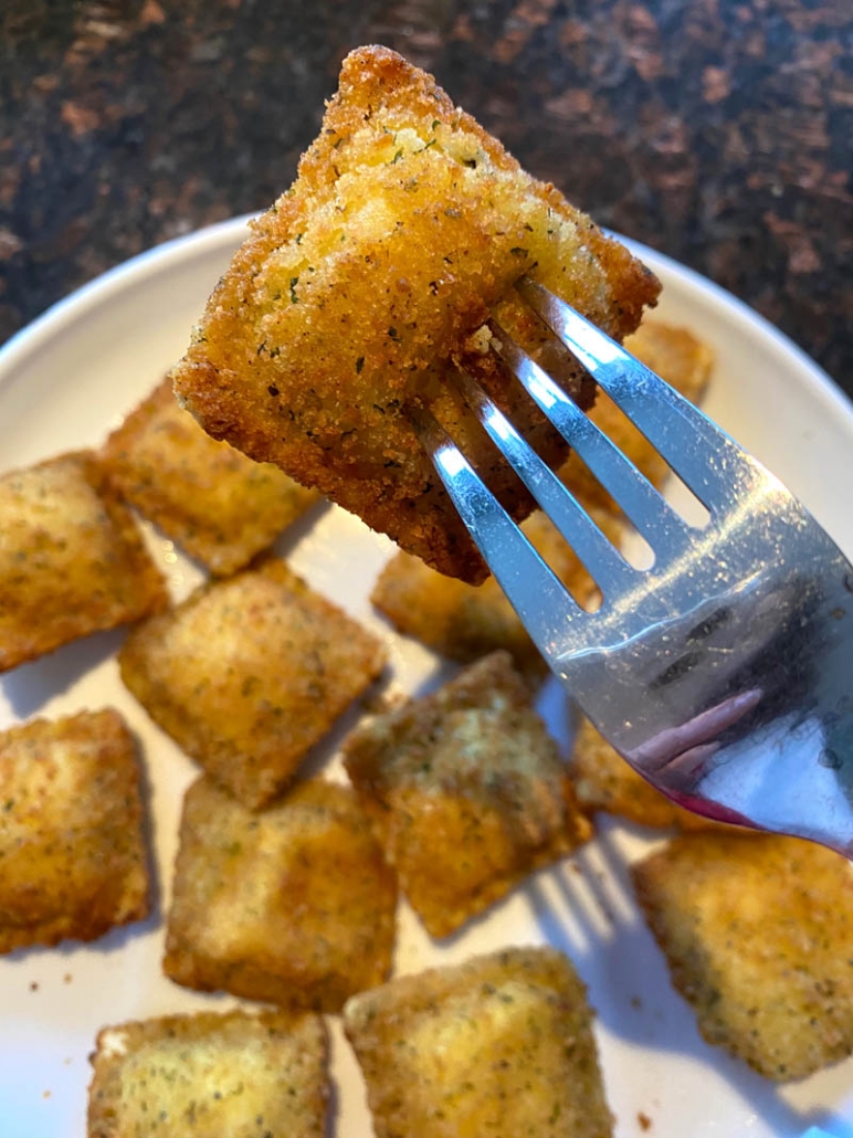 eating toasted ravioli with a fork 