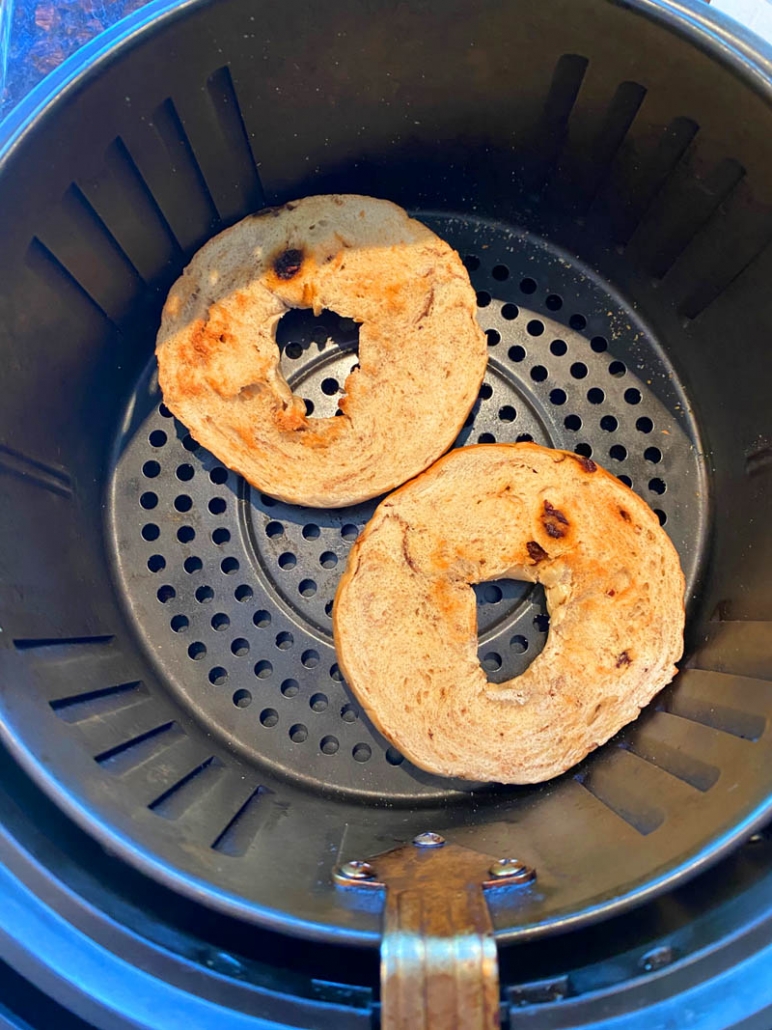 toasted bagels in an air fryer basket 