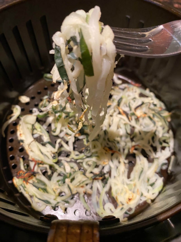 zucchini noodles in an air fryer basket 