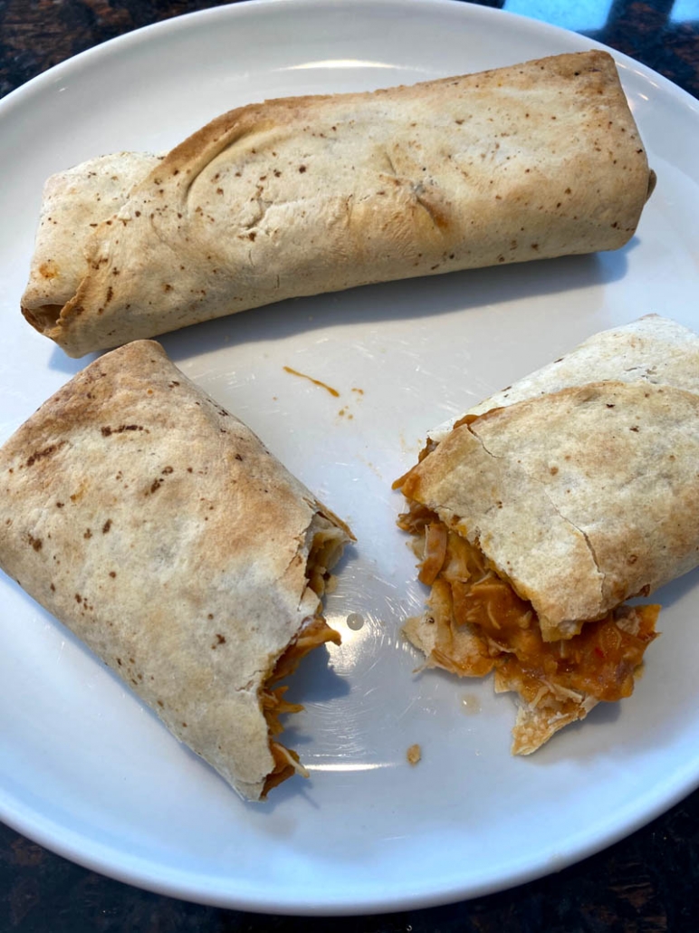 serving chicken burritos on white plate 