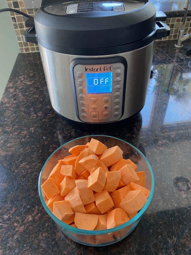 An Instant Pot and a bowl of raw cubed sweet potatoes 